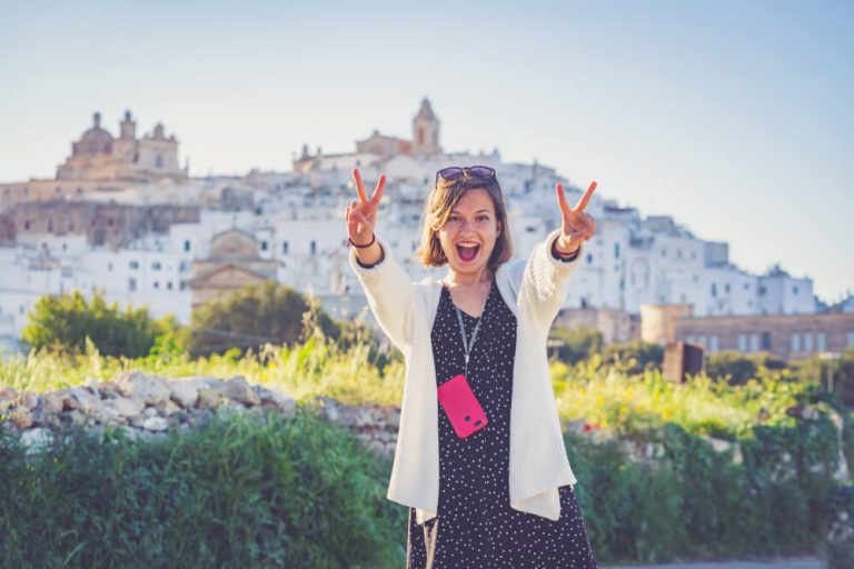 mooi meisje dat in het zuiden van Italië reist, maakt een foto-selfie in de straten van Ostuni, Apulië, Italië